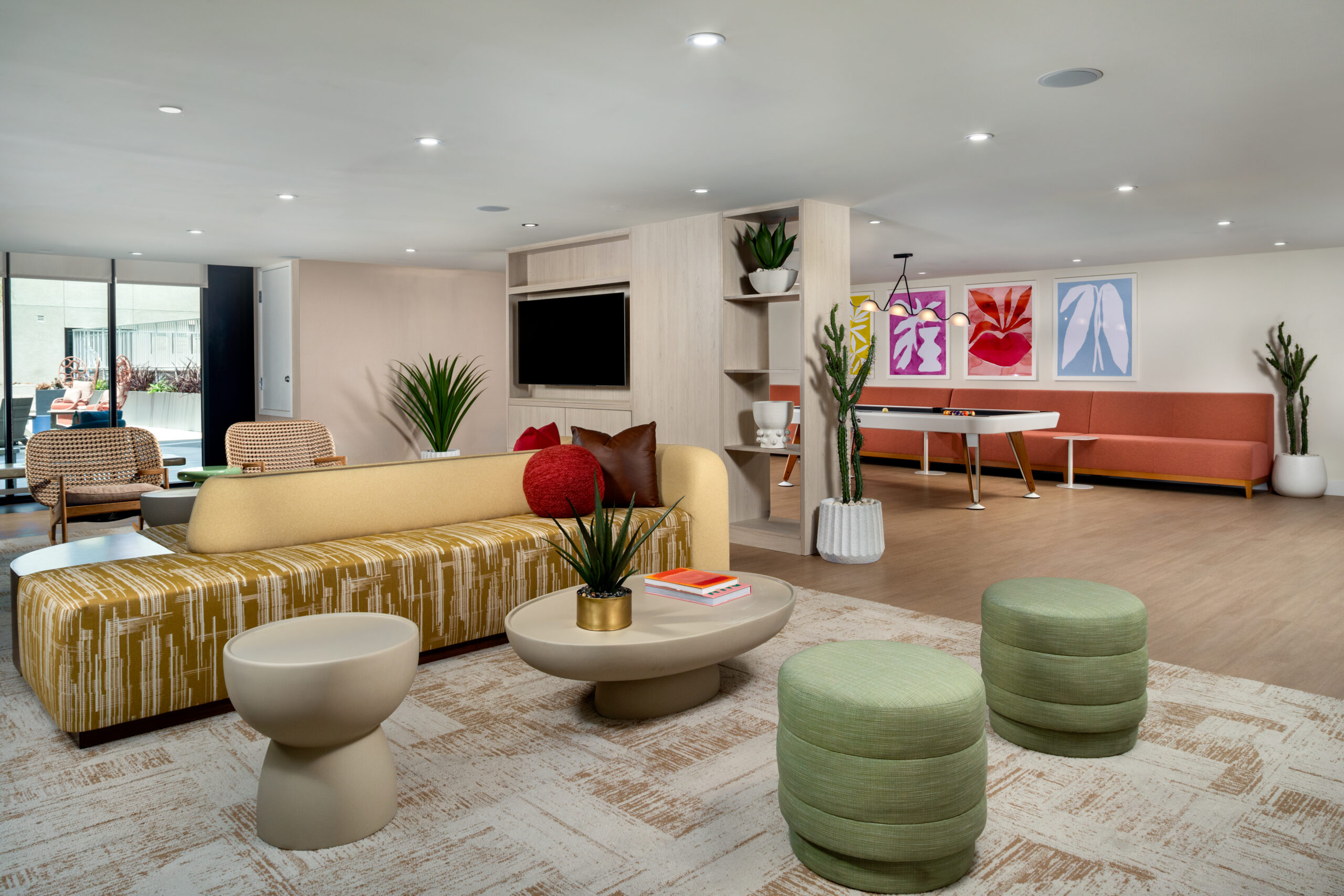 A resident lounge with couches, a table and stools, and a pool table.