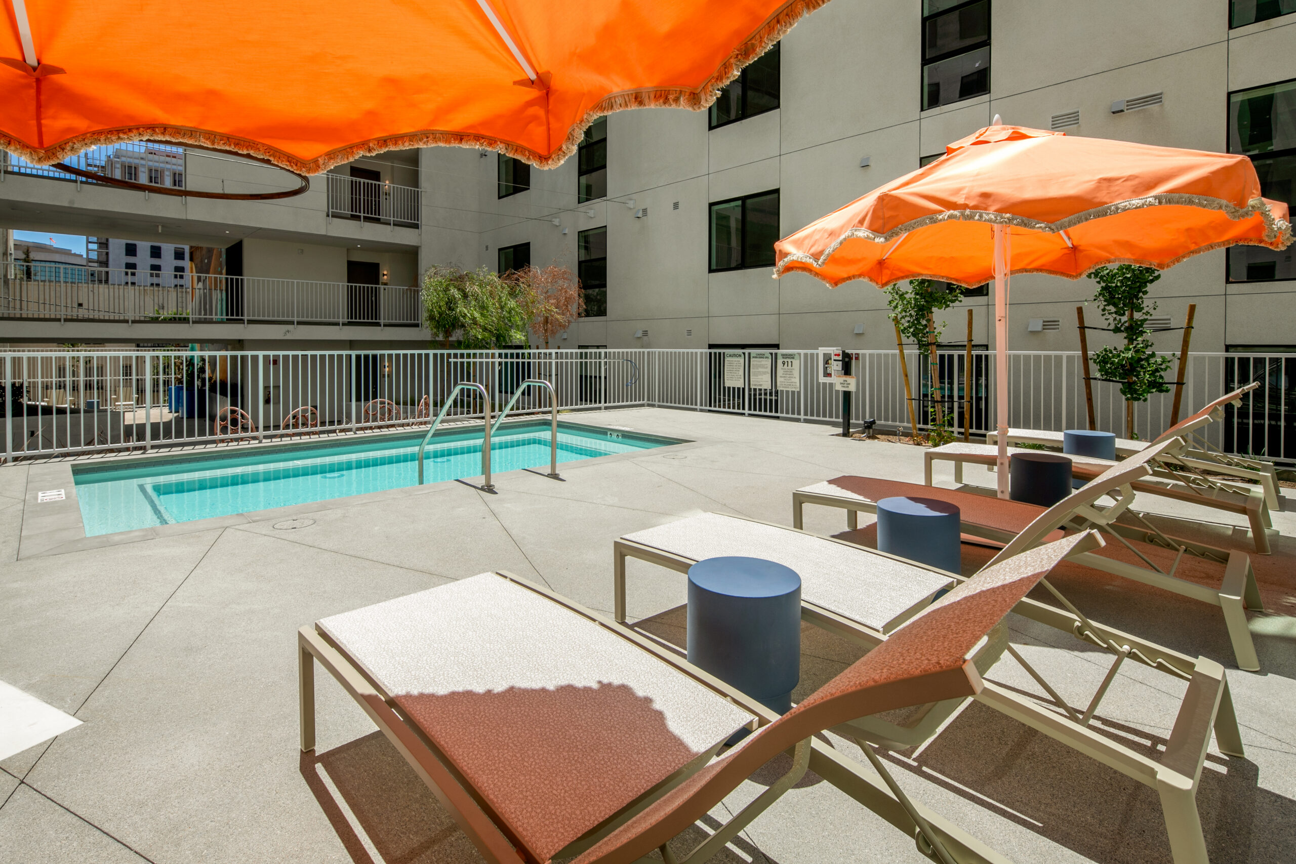 An outdoor pool deck with lounge chairs and umbrellas.